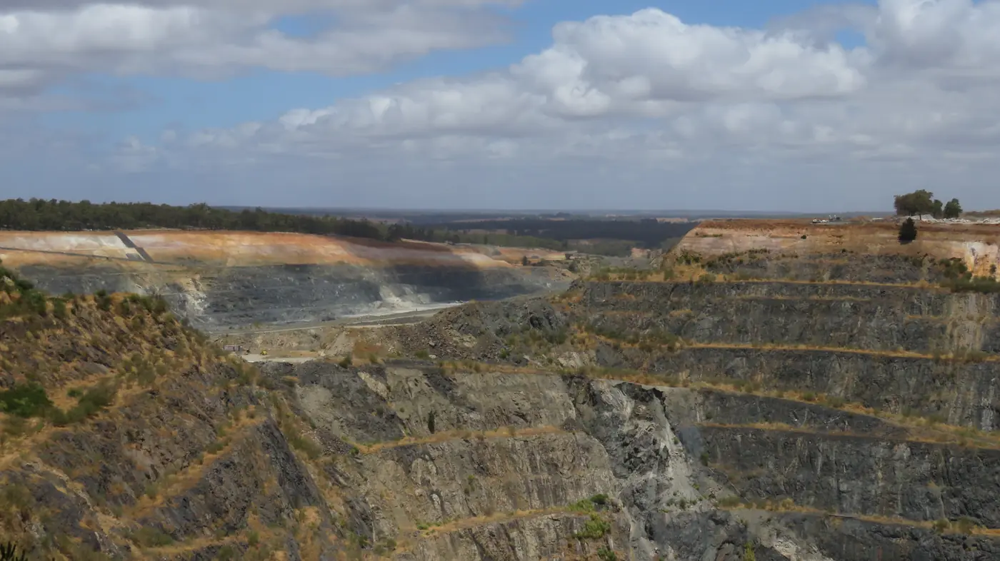 Terraced rock faces and exposed ground in an open pit at the Greenbushes mine in Western Australia
